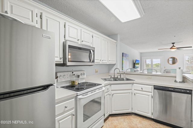 110 Ocean Hollow Ln Unit 114, Saint Augustine, FL 32084 - kitchen featuring appliances with stainless steel finishes, light countertops, white cabinets, a textured ceiling, and light tile patterned floors