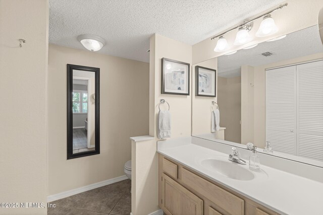 110 Ocean Hollow Ln Unit 114, Saint Augustine, FL 32084 - bathroom with a closet, vanity, a textured ceiling, and tile patterned flooring