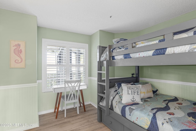 110 Ocean Hollow Ln Unit 114, Saint Augustine, FL 32084 - bedroom with wood finished floors, wainscoting, and a textured ceiling