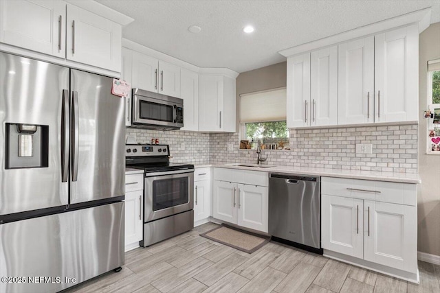 325 Sargo Rd, Atlantic Beach, FL 32233 - kitchen with stainless steel appliances, light countertops, white cabinetry, backsplash, and light wood-style flooring