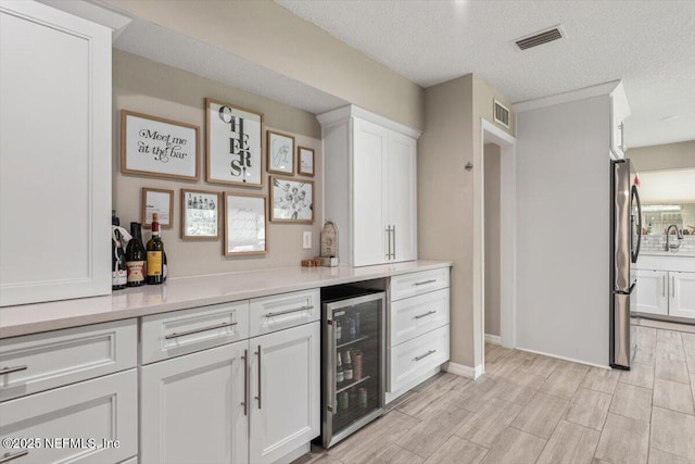 325 Sargo Rd, Atlantic Beach, FL 32233 - indoor dry bar featuring wine cooler, freestanding refrigerator, a textured ceiling, and light wood-style floors