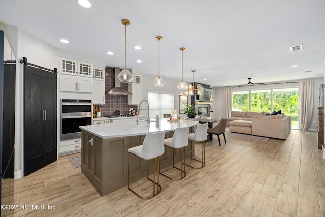 347 Ness Cir, Saint Augustine, FL 32095 - kitchen featuring double oven, wall chimney exhaust hood, light wood-style floors, light countertops, and recessed lighting