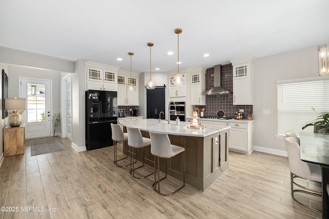 347 Ness Cir, Saint Augustine, FL 32095 - kitchen featuring freestanding refrigerator, wall chimney range hood, light countertops, light wood-style flooring, and tasteful backsplash