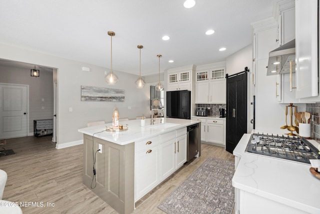 347 Ness Cir, Saint Augustine, FL 32095 - kitchen with range hood, appliances with stainless steel finishes, backsplash, a barn door, and white cabinets