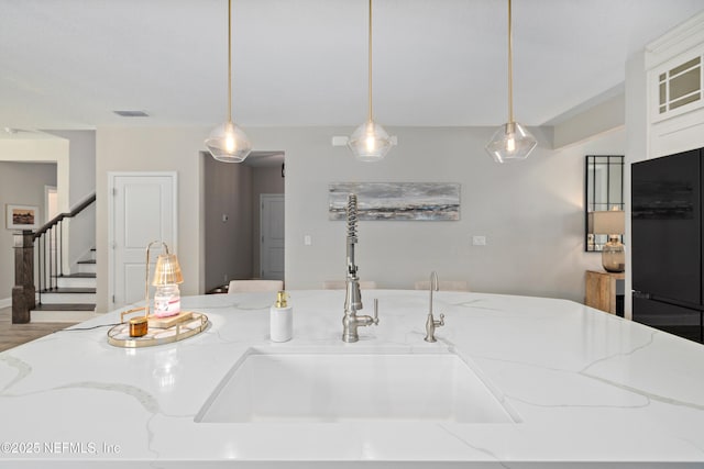 347 Ness Cir, Saint Augustine, FL 32095 - kitchen featuring freestanding refrigerator, hanging light fixtures, and light stone counters