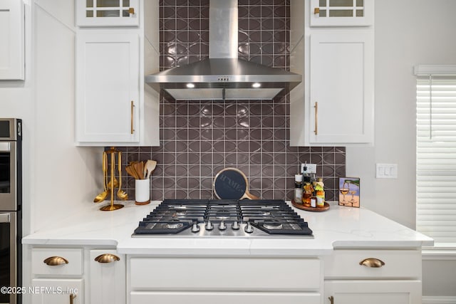 347 Ness Cir, Saint Augustine, FL 32095 - kitchen with wall chimney exhaust hood, stainless steel gas cooktop, white cabinets, and backsplash