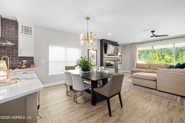 347 Ness Cir, Saint Augustine, FL 32095 - dining room featuring a brick fireplace, light wood-type flooring, and a chandelier