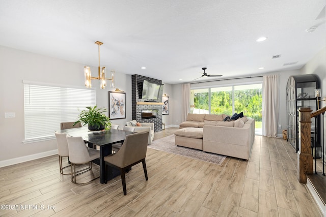 347 Ness Cir, Saint Augustine, FL 32095 - dining area with light wood-style flooring, a large fireplace, a chandelier, ceiling fan, and recessed lighting