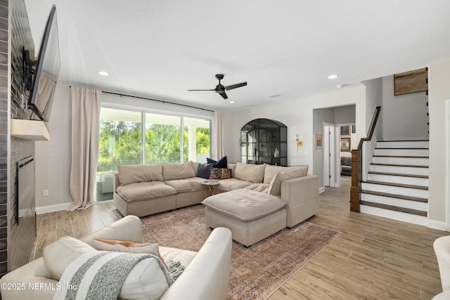 347 Ness Cir, Saint Augustine, FL 32095 - living room with a brick fireplace, a ceiling fan, light wood-type flooring, stairs, and arched walkways