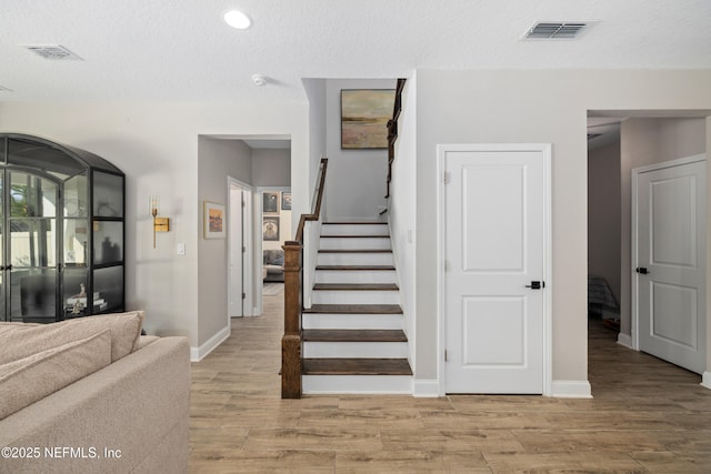 347 Ness Cir, Saint Augustine, FL 32095 - stairs featuring wood finished floors, a textured ceiling, and recessed lighting