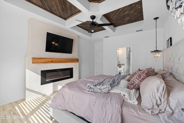 347 Ness Cir, Saint Augustine, FL 32095 - bedroom featuring coffered ceiling, wood finished floors, a glass covered fireplace, beam ceiling, and a chandelier