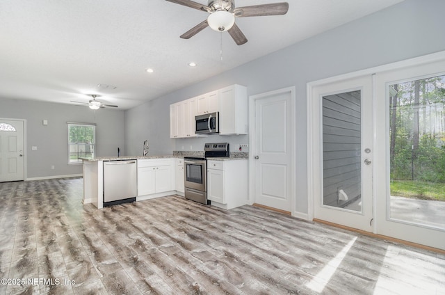 4725 Melanie St, Hastings, FL 32145 - kitchen with stainless steel appliances, a ceiling fan, a peninsula, white cabinetry, and recessed lighting