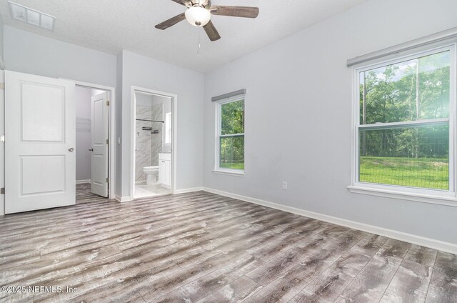 4725 Melanie St, Hastings, FL 32145 - unfurnished bedroom with wood finished floors, ensuite bathroom, ceiling fan, and a spacious closet