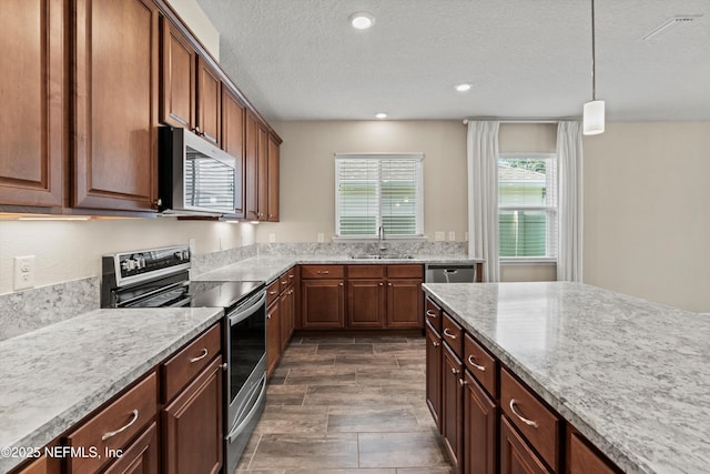 12206 Orange Grove Dr, Jacksonville, FL 32223 - kitchen with appliances with stainless steel finishes, pendant lighting, a textured ceiling, recessed lighting, and light stone counters