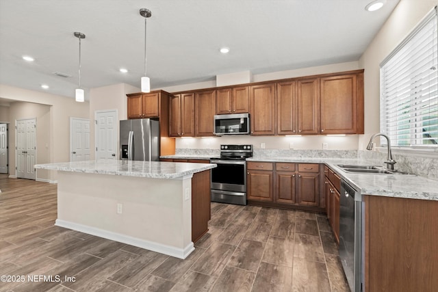 12206 Orange Grove Dr, Jacksonville, FL 32223 - kitchen with appliances with stainless steel finishes, dark wood-style floors, brown cabinetry, a kitchen island, and light stone counters