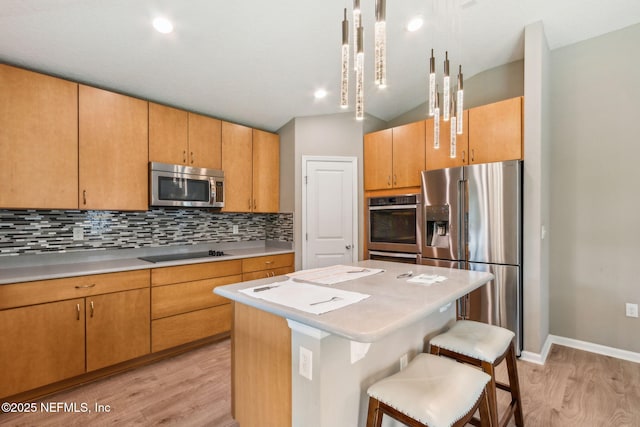 7250 Steventon Way, Jacksonville, FL 32244 - kitchen featuring appliances with stainless steel finishes, light wood-style flooring, light countertops, tasteful backsplash, and a center island