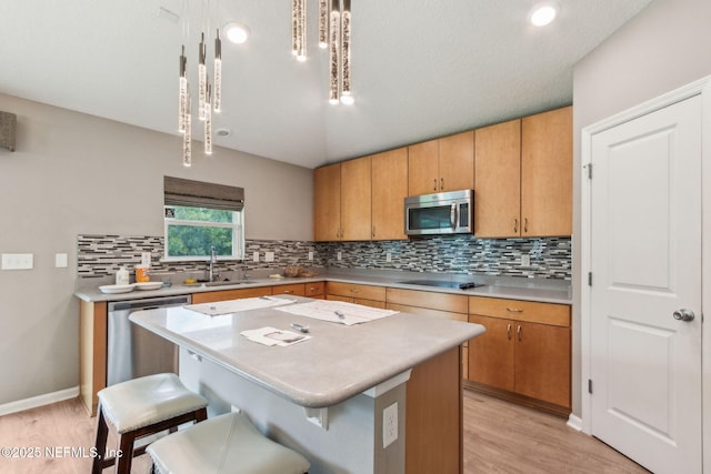 7250 Steventon Way, Jacksonville, FL 32244 - kitchen featuring stainless steel appliances, a kitchen breakfast bar, light countertops, and light wood-style floors