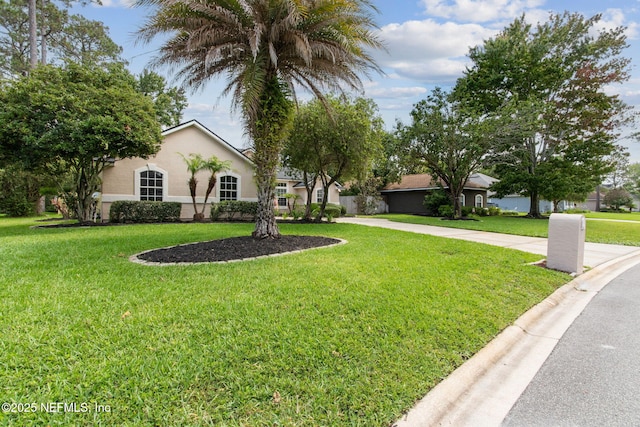 1912 Bluebonnet Way, Fleming Island, FL 32003 - view of front facade with stucco siding, a front yard, and driveway
