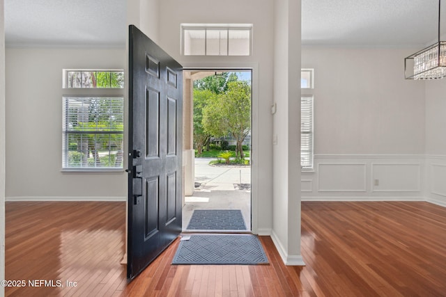 1912 Bluebonnet Way, Fleming Island, FL 32003 - entryway featuring hardwood / wood-style floors, ornamental molding, plenty of natural light, a chandelier, and wainscoting