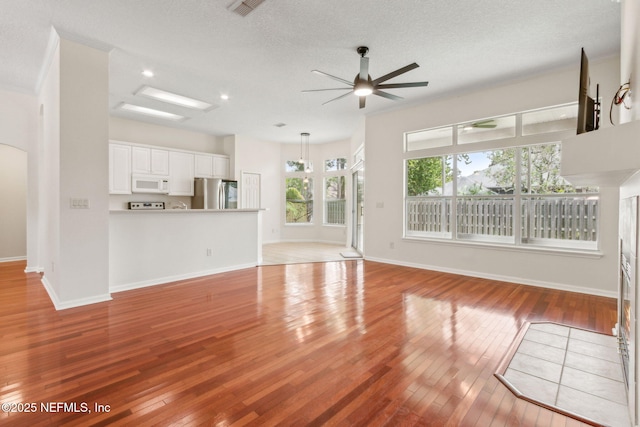 1912 Bluebonnet Way, Fleming Island, FL 32003 - unfurnished living room featuring plenty of natural light, light wood-type flooring, a ceiling fan, a textured ceiling, and recessed lighting