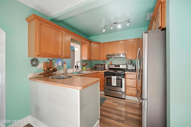 622 7th Ave N, Jacksonville Beach, FL 32250 - kitchen with appliances with stainless steel finishes, under cabinet range hood, a peninsula, light wood-style floors, and light countertops