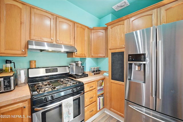 622 7th Ave N, Jacksonville Beach, FL 32250 - kitchen with stainless steel appliances, under cabinet range hood, light brown cabinets, and light countertops