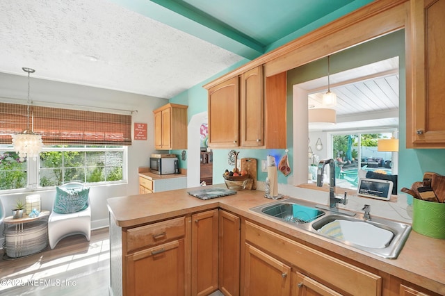 622 7th Ave N, Jacksonville Beach, FL 32250 - kitchen with light countertops, pendant lighting, stainless steel microwave, and a peninsula