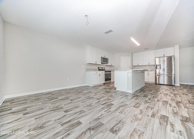 154 Moorcroft Way, Saint Augustine, FL 32092 - kitchen featuring appliances with stainless steel finishes, open floor plan, light wood-style floors, and white cabinetry
