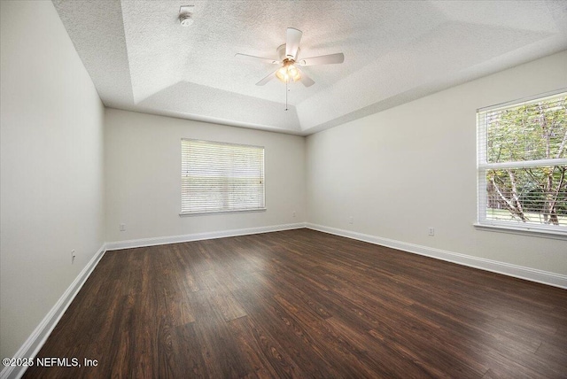 409 Spring Ridge Ct, Saint Augustine, FL 32092 - spare room with dark wood-style floors, a tray ceiling, a ceiling fan, and a textured ceiling