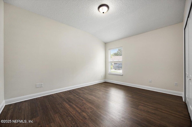 409 Spring Ridge Ct, Saint Augustine, FL 32092 - spare room with dark wood-style flooring, vaulted ceiling, and a textured ceiling