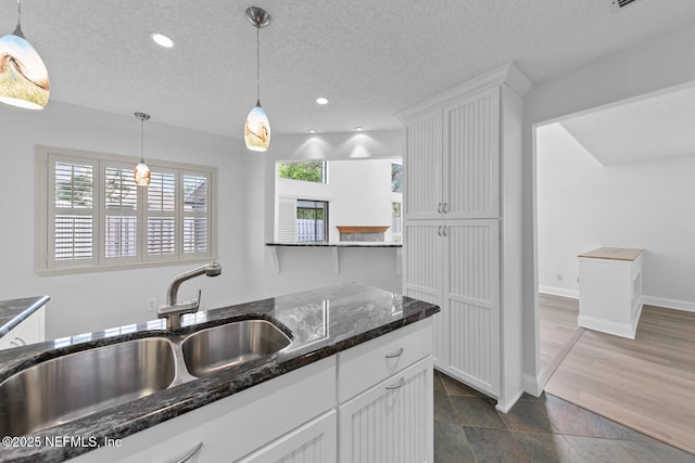 511 Selva Lakes Cir, Atlantic Beach, FL 32233 - kitchen featuring white cabinetry, a textured ceiling, hanging light fixtures, dark stone counters, and recessed lighting