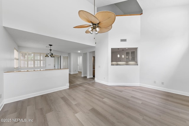 511 Selva Lakes Cir, Atlantic Beach, FL 32233 - unfurnished living room with wood finished floors, a chandelier, a high ceiling, and ceiling fan
