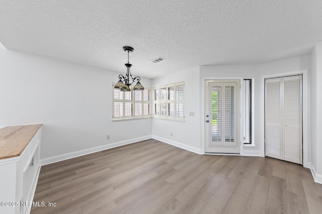 511 Selva Lakes Cir, Atlantic Beach, FL 32233 - unfurnished dining area with a chandelier, wood finished floors, and a textured ceiling