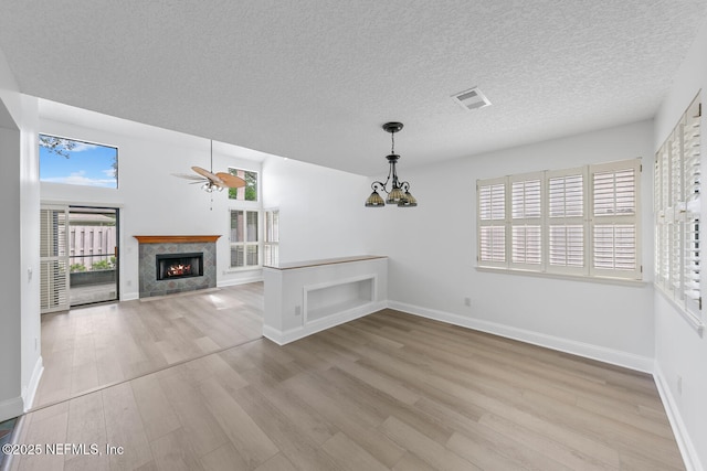 511 Selva Lakes Cir, Atlantic Beach, FL 32233 - unfurnished living room with light wood-style flooring, plenty of natural light, a premium fireplace, a ceiling fan, and a textured ceiling