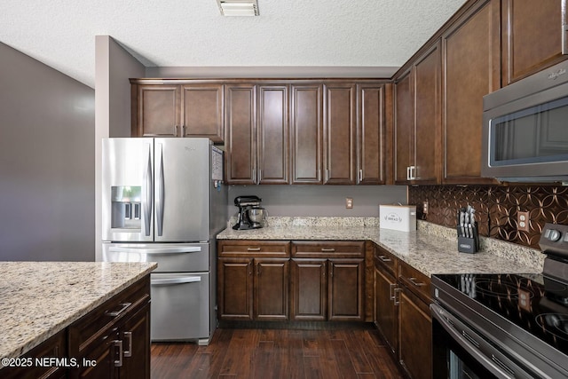 1341 River City St, Saint Augustine, FL 32092 - kitchen with appliances with stainless steel finishes, light stone counters, dark brown cabinetry, dark wood-style floors, and a textured ceiling