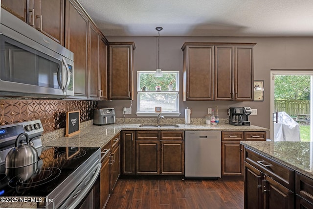 1341 River City St, Saint Augustine, FL 32092 - kitchen with stainless steel appliances, dark wood-style floors, light stone counters, and dark brown cabinetry