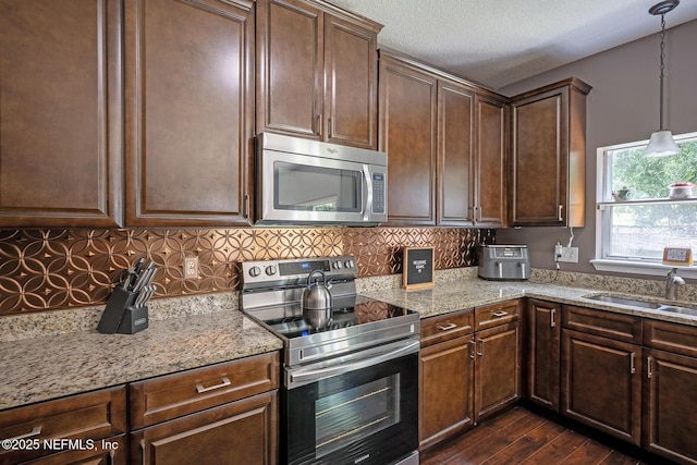 1341 River City St, Saint Augustine, FL 32092 - kitchen featuring stainless steel appliances, dark wood finished floors, light stone counters, tasteful backsplash, and a textured ceiling