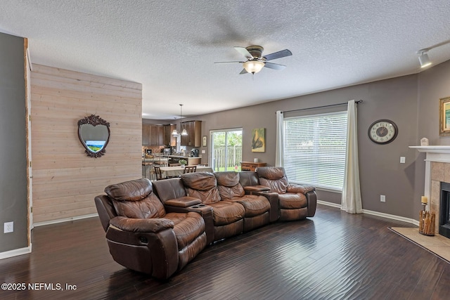 1341 River City St, Saint Augustine, FL 32092 - living room featuring ceiling fan, dark wood-type flooring, a tile fireplace, a textured ceiling, and wooden walls