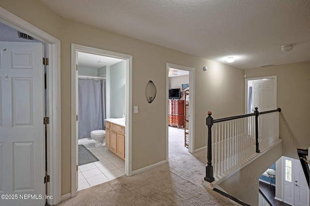 1341 River City St, Saint Augustine, FL 32092 - corridor with light colored carpet, an upstairs landing, a textured ceiling, and light tile patterned floors