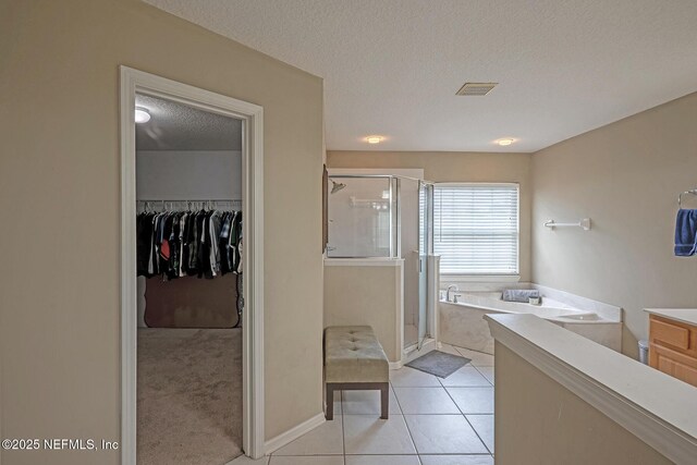 1341 River City St, Saint Augustine, FL 32092 - full bathroom featuring a stall shower, a bath, tile patterned floors, a textured ceiling, and a walk in closet