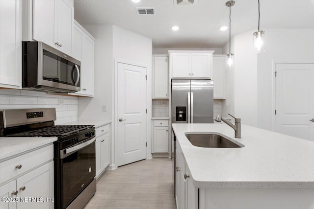 39 Thurnham Ln, Saint Augustine, FL 32092 - kitchen featuring stainless steel appliances, a kitchen island with sink, backsplash, white cabinetry, and recessed lighting