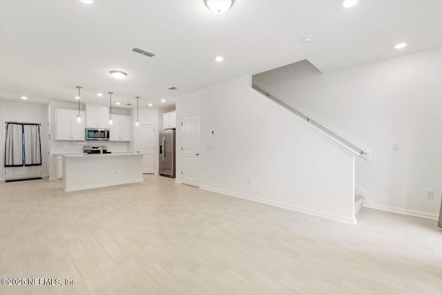 39 Thurnham Ln, Saint Augustine, FL 32092 - unfurnished living room with recessed lighting, light wood-style floors, and stairway