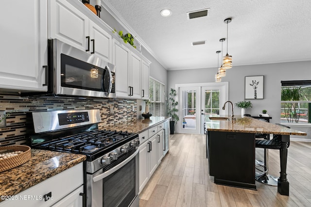 433 Big Tree Rd, Ponte Vedra Beach, FL 32082 - kitchen with stainless steel appliances, a kitchen breakfast bar, backsplash, white cabinets, and ornamental molding
