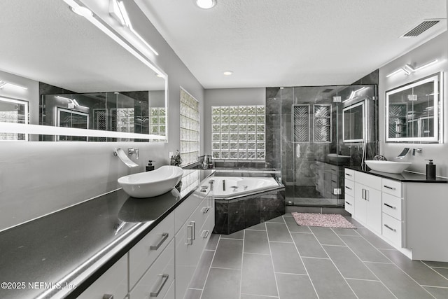 433 Big Tree Rd, Ponte Vedra Beach, FL 32082 - bathroom with a stall shower, a whirlpool tub, two vanities, a textured ceiling, and tile patterned flooring