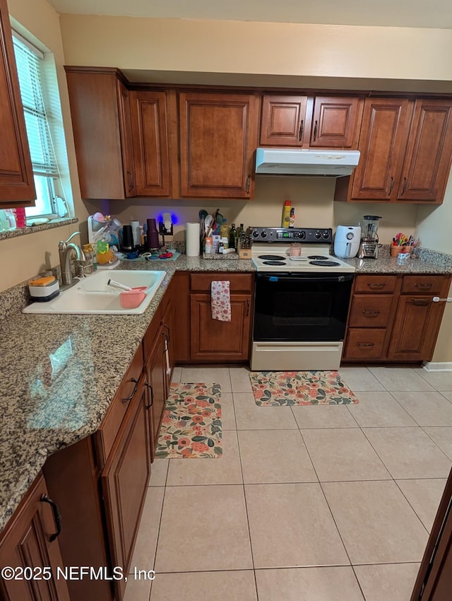 7505 Mayapple Rd, Jacksonville, FL 32211 - kitchen with range with electric stovetop, under cabinet range hood, and brown cabinetry