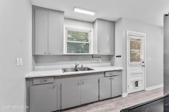 431 W 62nd St, Jacksonville, FL 32208 - kitchen with gray cabinetry, light wood finished floors, and light countertops
