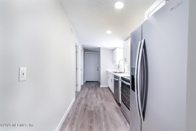 209 N 7th St, Palatka, FL 32177 - kitchen with stainless steel appliances, white cabinetry, light wood finished floors, light countertops, and recessed lighting