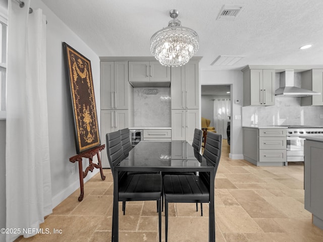 5062 N Ocean Shore Blvd, Palm Coast, FL 32137 - dining room featuring a chandelier, a textured ceiling, stone tile flooring, and recessed lighting