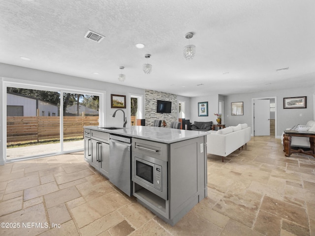 5062 N Ocean Shore Blvd, Palm Coast, FL 32137 - kitchen featuring appliances with stainless steel finishes, gray cabinets, stone tile flooring, a kitchen island with sink, and open floor plan