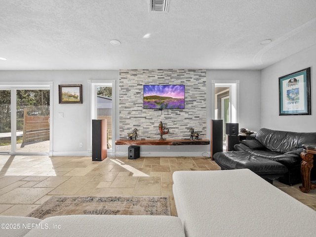 5062 N Ocean Shore Blvd, Palm Coast, FL 32137 - living area with stone tile flooring, a textured ceiling, and recessed lighting